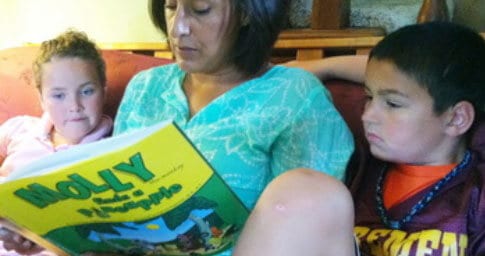 Parent reading Molly the Monkey to children